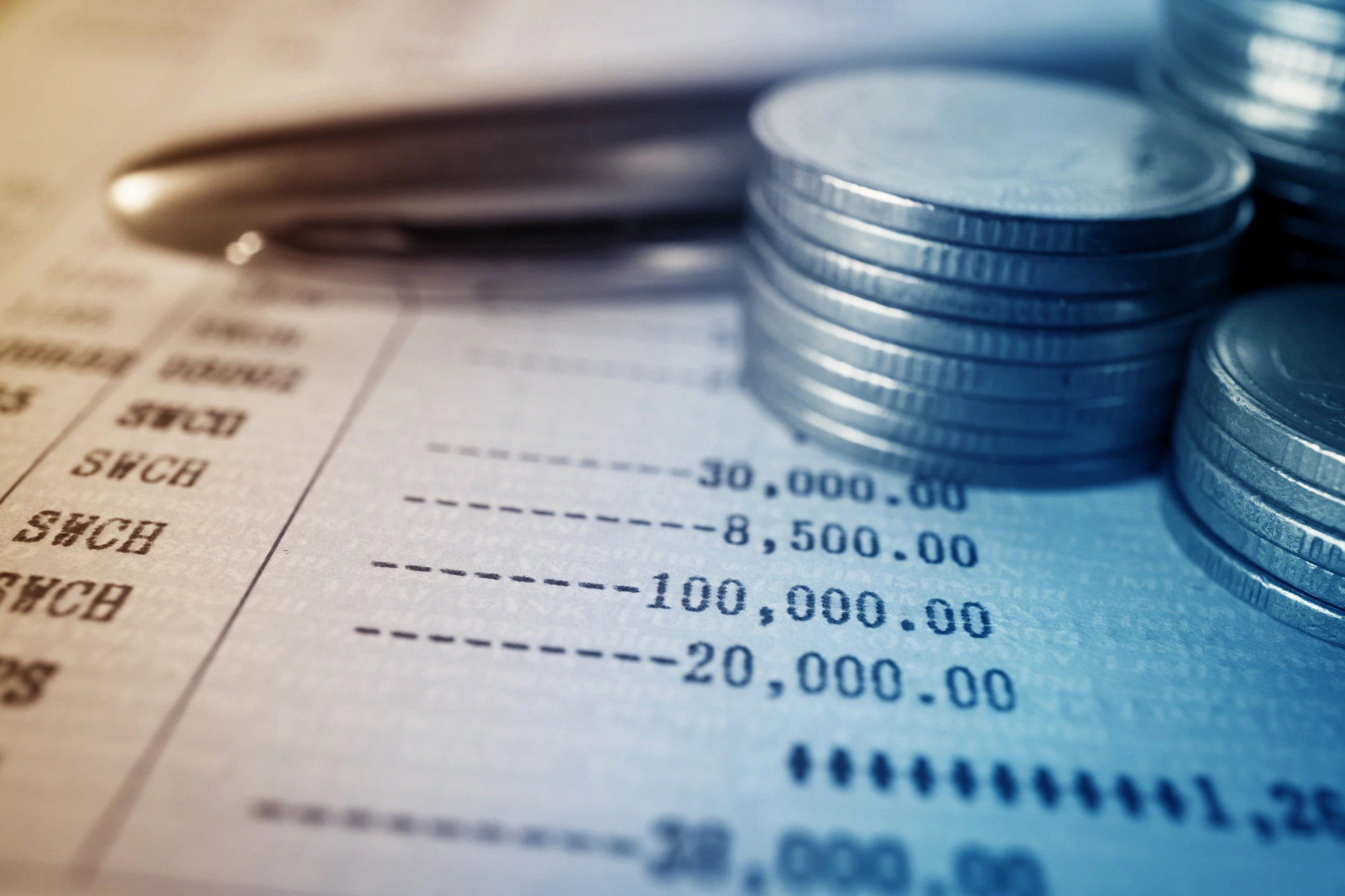 Estado de cuenta de cliente impreso con cargos, pagos y saldos junto a monedas