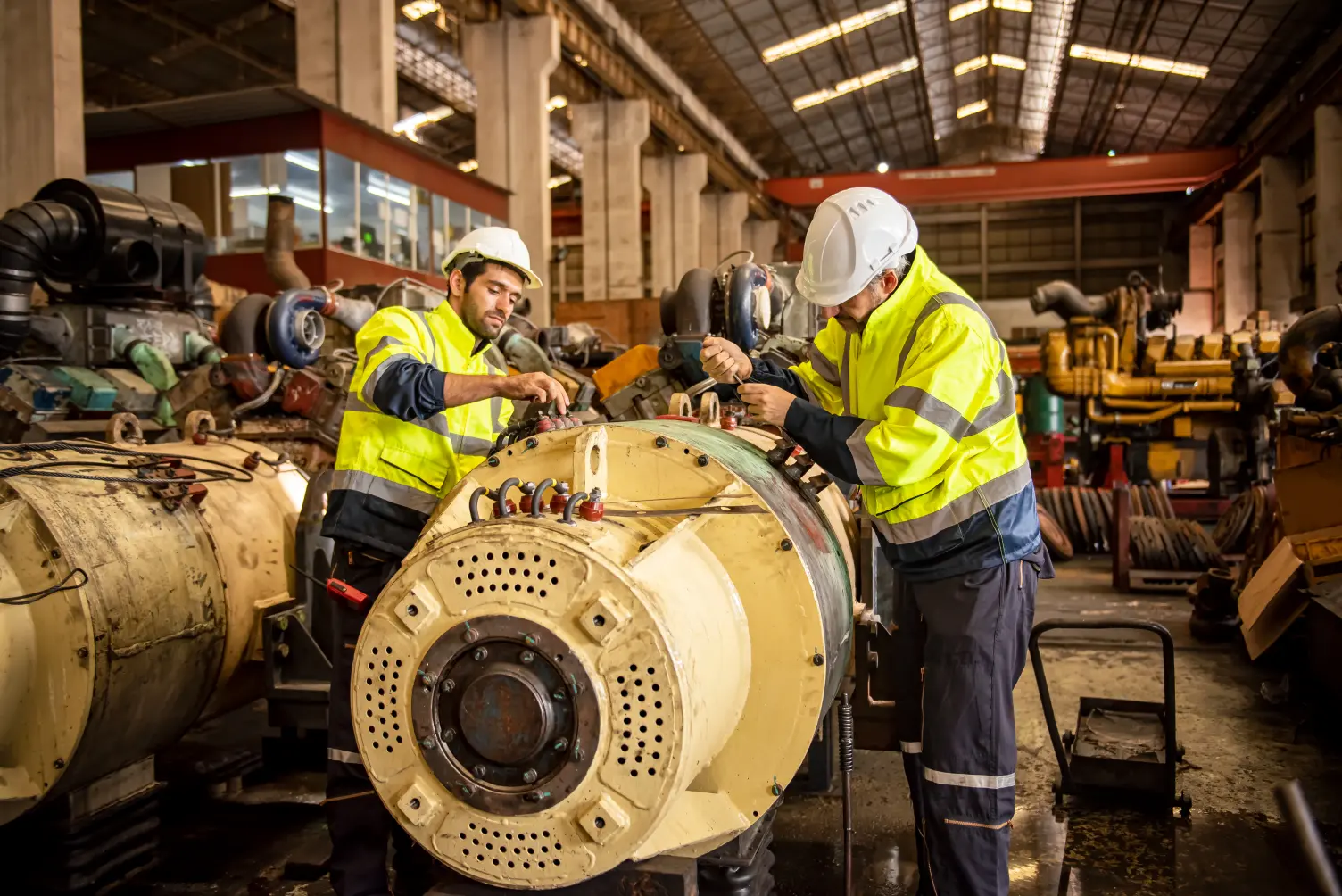 Técnicos de mantenimiento industrial reparando maquinaria en un taller